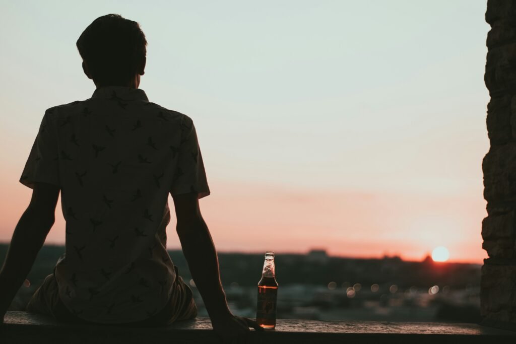 Man sitting watching the sunset from a building 