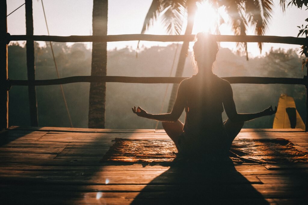 Person doing yoga on a balcony at sunrise